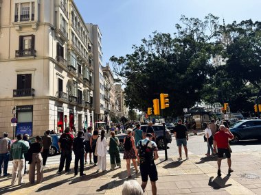Malaga, İspanya - 02 Mayıs 2025: Malaga 'da yayalar, güneş ışığı ve tarihi mimari ile dolu bir cadde