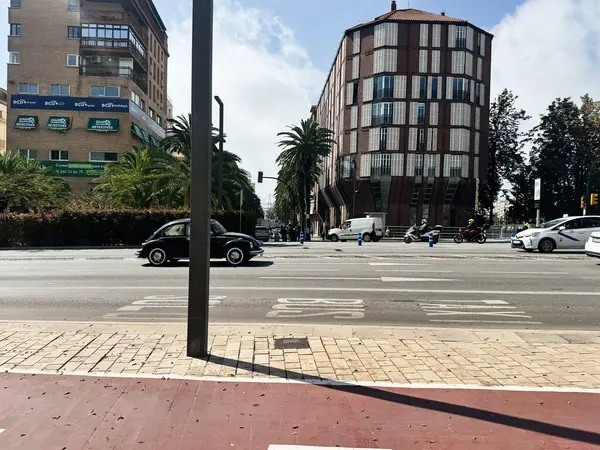Malaga, İspanya - 02 Mayıs 2025: Malaga, İspanya 'da hareketli bir şehir caddesi, araçlar ve binalarla kentsel yaşamı gözler önüne seriyor.