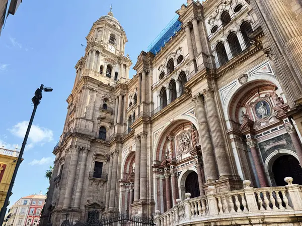 Malaga, İspanya - 02 Mayıs 2025: Malaga 'nın tarihi katedralinin heybetli mavi gökyüzüne karşı karmaşık taş cephesi