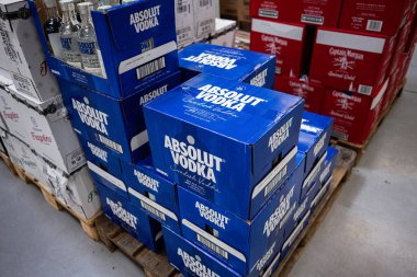 Ivano-Frankivsk, Ukrayna - 29 Nisan 2025: Absolut votka şişeleri bir depo paletinde düzenlenmiş büyük mavi kutular
