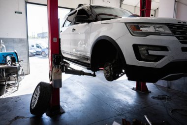 Kyiv, Ukrayna - 02 Mayıs 2025: Beyaz bir Ford Explorer SUV aracı bir oto tamirhanesinde tamir edilmek üzere kaldırıldı