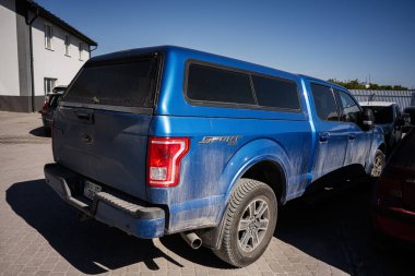 Kyiv, Ukrayna - 02 Mayıs 2025: Güneşli bir yerleşim bölgesinde evlerin yanına parkedilmiş mavi renkli Ford F-150