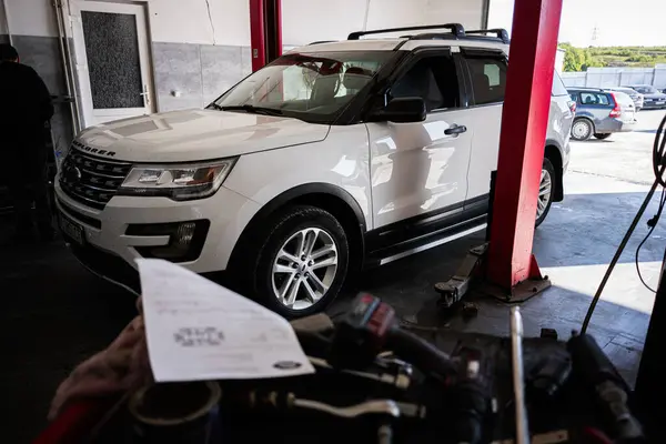 Kyiv, Ukrayna - 02 Mayıs 2025: Beyaz Ford Explorer SUV bakım ve onarım faaliyetleri için bir atölye içinde konumlandırıldı 