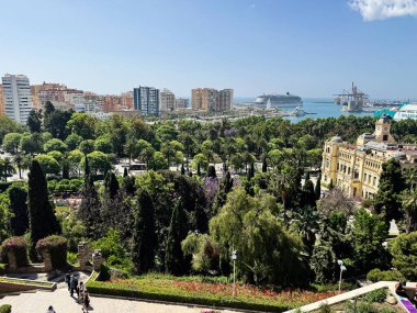 Malaga, İspanya - 02 Mayıs 2025: Bereketli yeşillik, canlı mimari ve Malaga 'nın canlı kentsel manzarasını gösteren liman