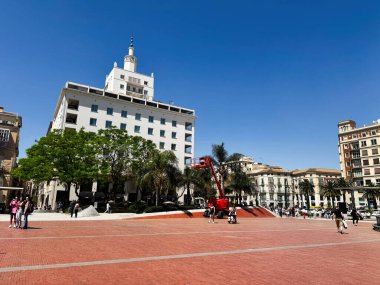 Malaga, İspanya - 02 Mayıs 2025: Malaga 'da güneşli bir gökyüzünün altında insan ve binalarla dolu bir meydanın manzarası.
