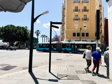 Malaga, İspanya - 02 Mayıs 2025: Malaga şehrinde yayalar, bir otobüs ve klasik mimarinin yer aldığı güneşli bir gün.