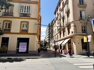 Malaga, İspanya - 02 Mayıs 2025: Malaga 'da binalar, yayalar ve güneşli bir atmosferin yer aldığı bir sokak manzarası.