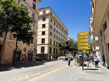 Malaga, İspanya - 02 Mayıs 2025: Malaga 'da güneş ışığı altında binalar, oteller ve yayalar bulunan şehir merkezi