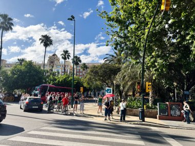 Malaga, İspanya - 02 Mayıs 2025: İspanya 'nın Malaga kentinde trafik, turizm ve tarihi mimari ile dolu hareketli cadde.
