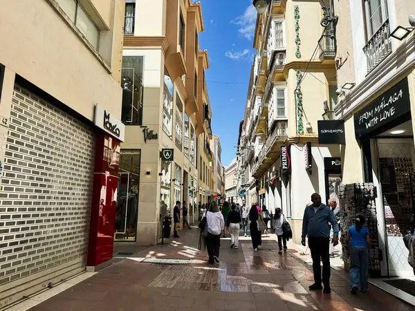 Malaga, İspanya - 02 Mayıs 2025: Parlak bir günde İspanya 'nın Malaga kentinden alışveriş yapan insanların sokak manzarası.