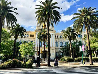 Malaga, İspanya - 02 Mayıs 2025: Malaga, İspanya 'da canlı palmiye ağaçları olan güzel tarihi mimari