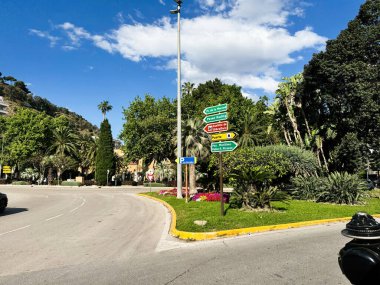 Malaga, İspanya - 02 Mayıs 2025: Güneşli bir günde Malaga 'da dekoratif bitki örtüsü, sokak tabelaları ve ağaçlarla dolu bir kavşak.