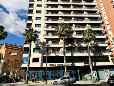 Malaga, İspanya - 02 Mayıs 2025: İspanya 'nın güneşli caddeleri Malaga' da palmiye ağaçları ve arabalarla çağdaş Maestranza cephesi