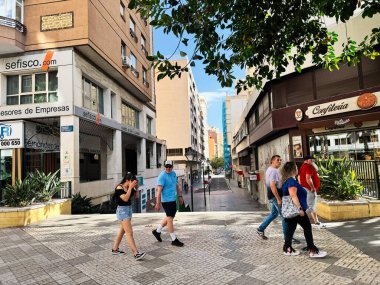 Malaga, İspanya - 02 Mayıs 2025: Malaga 'da çeşitli kentsel binalar arasında yürüyen yayaların yer aldığı canlı bir sokak manzarası.