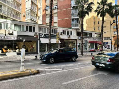 Malaga, İspanya - 02 Mayıs 2025: Trafikli, palmiye ağaçlı ve harici konutlu Malaga sokak manzarası
