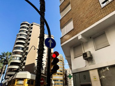 Malaga, İspanya - 02 Mayıs 2025: Malaga, İspanya 'da binalar, trafik işaretleri ve mavi gökyüzünün yer aldığı bir şehir manzarası.