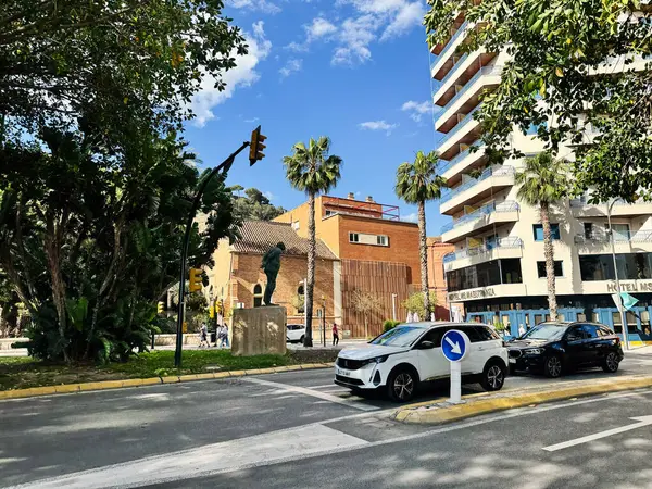 Malaga, İspanya - 02 Mayıs 2025: Yeşillik, binalar ve İspanya 'nın Malaga kentindeki heykeli.