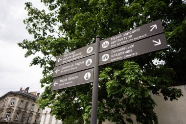Lviv, Ukrayna - Mayıs 04, 2025: Yön işaretleri yeşil alanda Lviv, Ukrayna 'da görülen doğa ve binaları gösteriyor. 