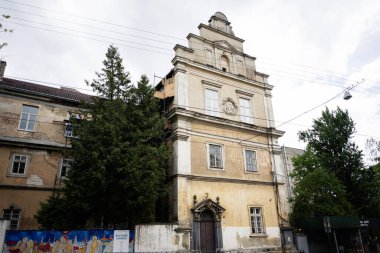 Lviv, Ukrayna - 04 Mayıs 2025: Yeşillik ve Ukrayna 'nın başkenti Lviv' de canlı bir duvar resmiyle çevrili mimari ayrıntılara sahip tarihi bina. 