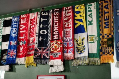 Lviv, Ukrayna - 4 Mayıs 2025: Futbol kulübü eşarpları yeşil bir duvarda canlı renkler ve çeşitli tasarımlar sergilendi.