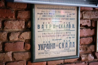 Lviv, Ukrayna - 4 Mayıs 2025: 1943 tarihli antika spor posteri çerçevelenmiş ve bir kafedeki tuğla duvara asılmış