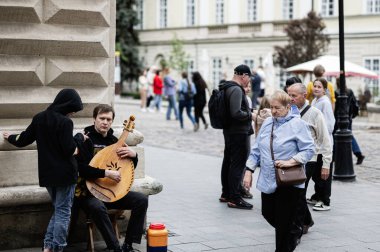 Lviv, Ukrayna - 4 Mayıs 2025: Müzisyen, Ukrayna 'nın Lviv kentinde insanlar geçerken sokakta bandura teli çalıyor. 