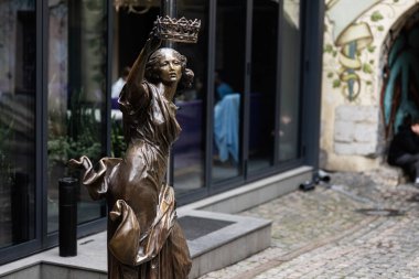 Lviv, Ukrayna - 4 Mayıs 2025: Ukrayna 'nın Lviv kentinde halka açık bir alanda taç tutan bir kadının büyüleyici bronz heykeli. 