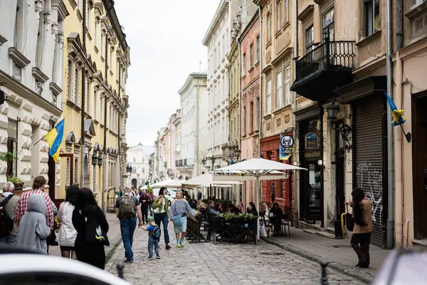 Lviv, Ukrayna - 04 Mayıs 2025: Lviv, Ukrayna 'da kafeler, yayalar ve renkli mimarilerle dolu tarihi kaldırım taşı caddesi. 