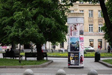 Lviv, Ukrayna - 04 Mayıs 2025: Lviv, Ukrayna 'da huzurlu bir şehir parkında posterlerle kaplı reklam köşesi. 
