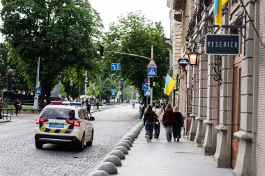 Lviv, Ukrayna - 4 Mayıs 2025: Polis arabası, yaya geçidi ve Lviv, Ukrayna 'dan geçen insanlar. 
