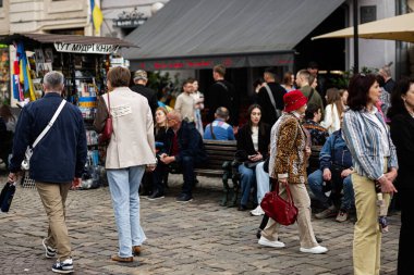 Lviv, Ukrayna - 04 Mayıs 2025: Ukrayna 'nın Lviv kentindeki kaldırım taşı meydanında yayalar, banklar ve hareketli bir atmosfer sahnesi. 