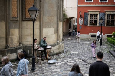 Lviv, Ukrayna - 4 Mayıs 2025: Müzisyenler Ukrayna 'nın Lviv kentinde mimariyle çevrili canlı bir kaldırım taşı meydanında davul çalıyorlar. 