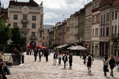 Lviv, Ukrayna - 04 Mayıs 2025: Tarihi mimarisi, kaldırım taşı yolu ve Lviv, Ukrayna 'da gezinen kişiler ile kentsel sokak manzarası. 