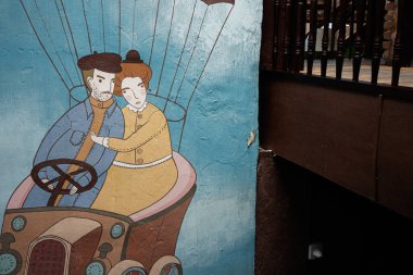 Lviv, Ukrayna - 4 Mayıs 2025: Canlı renklerin yer aldığı iki kişilik bir arabanın duvarındaki resim.
