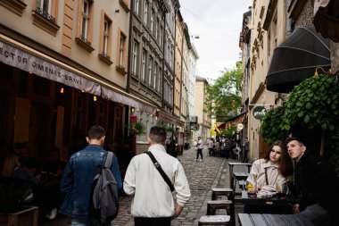 Lviv, Ukrayna - 04 Mayıs 2025: Lviv, Ukrayna 'da sokak aktivitelerini, kafe yemeklerini ve kentsel sosyal etkileşimleri yakalayan canlı bir şehir manzarası. 