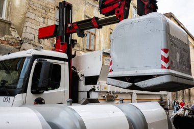 Lviv, Ukrayna - 04 Mayıs 2025: Lviv, Ukrayna 'da bir çöp konteynırını kaldırmak ve boşaltmak için faaliyet gösteren atık yönetimi kamyonu. 