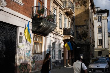 Lviv, Ukrayna - 04 Mayıs 2025: Şehir manzarası Lviv, Ukrayna 'da bina cepheleri, ulusal bayraklar ve yürüyen şahısları gösteriyor. 