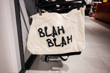 Bir dükkanda belirgin bir şekilde sergilenen, 'blah blah' metni ile bez çanta şık
