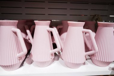 Ekran raflarına dizayn edilmiş çoklu pembe kil sürahileri