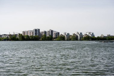 Doğayla çevrili huzurlu bir su kütlesinin yanında güzel kentsel apartmanlar.