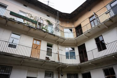 Çok katlı eski bir konut yapısında balkon ve pencereleri gösteren perspektif