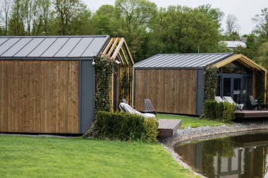 Etrafı yeşillik ve ağaçlarla çevrili ahşap kulübeler dingin bir ortam yaratıyor.