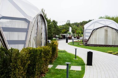 Manikürlü yeşil alanlarla çevrili bir çevre yolu üzerinde jeodezik kubbeler..