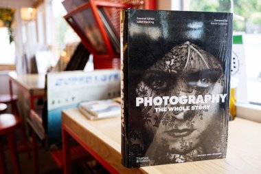Lviv, Ukrayna - 04 Mayıs 2025: Fotoğrafçılık hakkında bir ciltli kitap doğal ışıklandırmada ahşap bir masada sergilendi