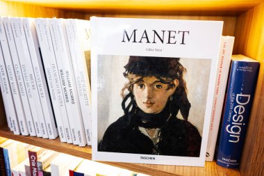 Lviv, Ukrayna - 04 Mayıs 2025: Manet 'in diğer tasarım edebiyatıyla çevrili olduğu bir sanat kitabının yer aldığı kitaplık.