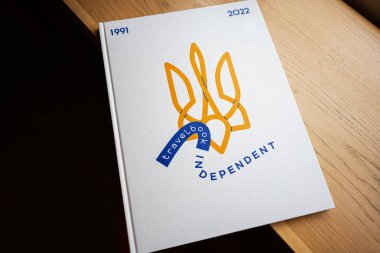 Lviv, Ukrayna - 04 Mayıs 2025: Modern dekoratif tasarımı olan ahşap bir masaya yerleştirilmiş şık bir Independent ciltli kitap