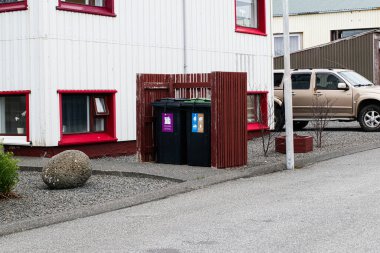 Akranes, İzlanda - 15 Mayıs 2025: Akranes, İzlanda 'da bir evin önünde atık atmak için iki tekerlekli çöp kutusu