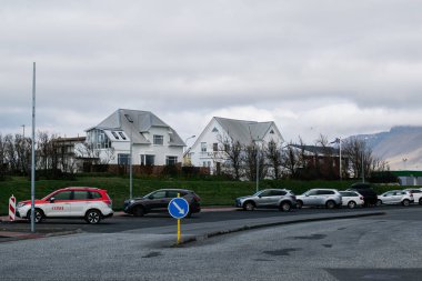 Akranes, İzlanda - 15 Mayıs 2025: İzlanda 'nın Akranes kentinde park halindeki arabaları ve beyaz evleri olan İzlanda manzaralı yerleşim yeri.