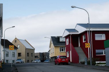 Akranes, İzlanda - 15 Mayıs 2025: İzlanda 'nın Akranes kentinde renkli İzlanda evleri ve trafik işaretlerinin yer aldığı canlı bir sokak sahnesi