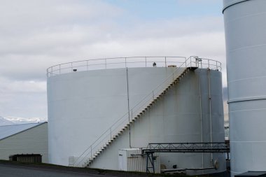 Akranes, İzlanda - 15 Mayıs 2025: Akranes, İzlanda 'da merdivenleri ve güvenlik korkulukları olan büyük beyaz depolama tankı tesisleri
